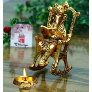 Golden Lord Ganesha Statue Sitting On A Rocking Chair And Reading Ramayan Showpiece